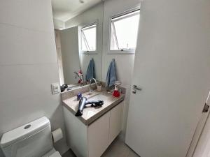 a bathroom with a sink and a toilet and a mirror at STUDIO COMPLETO - CENTRO - Com GARAGEM in Juiz de Fora