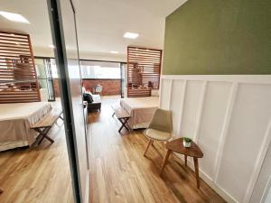 a room with two beds and a table and a chair at STUDIO COMPLETO - CENTRO - Com GARAGEM in Juiz de Fora