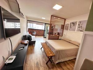 a bedroom with a bed and a desk in a room at STUDIO COMPLETO - CENTRO - Com GARAGEM in Juiz de Fora