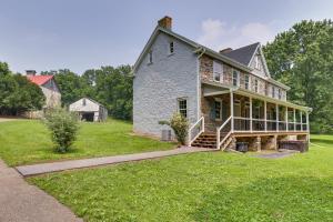 una antigua casa de piedra con un porche en el césped en Spacious Country Home in Coatesville on Old Ranch!, en Coatesville