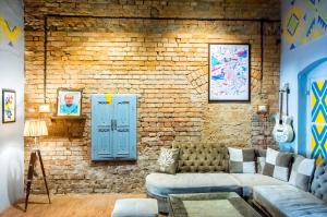 a living room with a couch and a brick wall at International Travellers' Hostel by ITH Stays in Varanasi