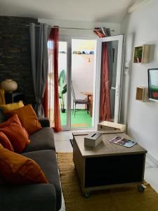 een woonkamer met een bank en een tafel bij Cosy avec patio en bord de lac in Istres