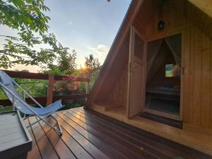 ein kleines Holzhaus mit einem Stuhl auf einer Terrasse in der Unterkunft Ozy's place in Kamnik