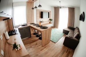 eine Küche und ein Wohnzimmer mit einem Tisch und einem Sofa in der Unterkunft Cosy apartment Bucovina in Suceava