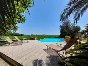 a wooden deck with chairs and a swimming pool at Le CAMPAGNE in Beaucaire
