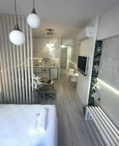 a bedroom with a white bed and a kitchen at Lindy V in Athens