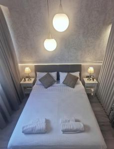 a bedroom with a large white bed with two pillows at Lindy V in Athens