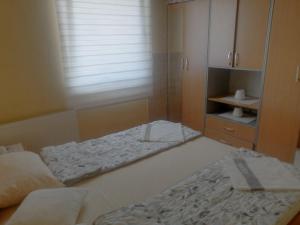a small bedroom with two beds and a cabinet at Apartman Mitrovići Bajina Bašta in Bajina Bašta