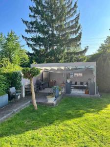 un patio con un árbol y un pabellón con un árbol en Stadtvilla am Park Heilbronn Pfühlpark, en Heilbronn