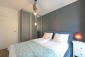 a bedroom with a bed with a blue head board at Front Park by Q4Apartments in Gdańsk