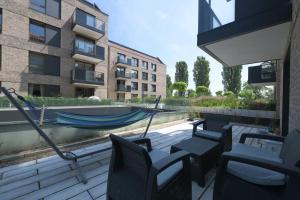 a patio with chairs and a hammock and a building at Front Park by Q4Apartments in Gdańsk