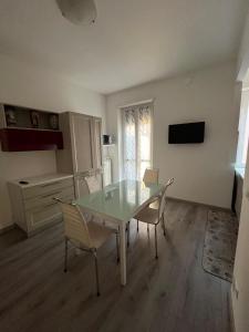 Un comedor con una mesa de cristal y sillas. en Santa Rita, en Turín