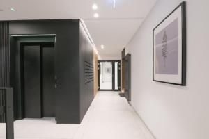 a hallway with black and white walls and a white floor at Front Park by Q4Apartments in Gdańsk