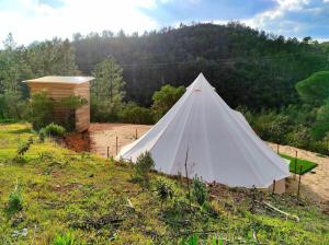 a white teepee on a hill with a forest at Parque da Mina in Monchique