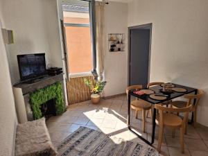 uma sala de estar com uma mesa e cadeiras e uma televisão em Appartement Stockholm em Gap
