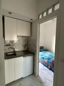- une cuisine avec évier et un lit dans une chambre dans l'établissement Al Porto Di Roma B&B, à Lido di Ostia