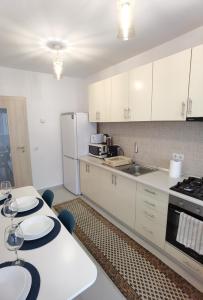 una cocina con armarios blancos y encimeras blancas en Select Apartment SIBIU en Sibiu