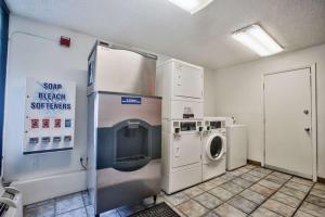 lavadero con nevera, lavadora y secadora en Loyalty Inn Tallahassee, en Tallahassee
