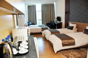 a hotel room with two beds and a table at Byblostar Hotel in Jbeil