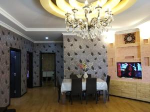 ein Esszimmer mit einem Tisch und einem Kronleuchter in der Unterkunft Elnur small villa in Daşca