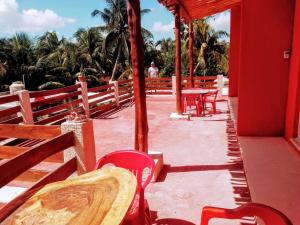 a patio with red tables and chairs and palm trees at Tribe Beachville in El Cuyo