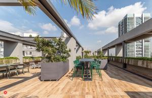 einen Balkon mit einem Tisch und Stühlen auf einem Gebäude in der Unterkunft Casa Taman by Kukun in Mexiko-Stadt