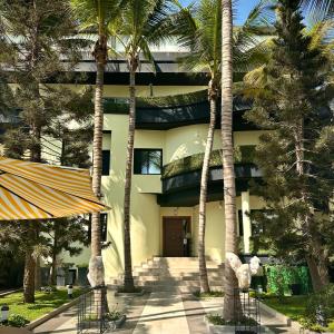 budynek z palmami przed nim w obiekcie THE PALMS Luxury Boutique Hotel w mieście Dakar