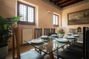 comedor con mesa de cristal y sillas en Villa Cecilia - pieds dans l'eau, en Sulzano