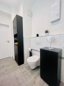 a bathroom with a white toilet and a black cabinet at HarzFokus - Happynest - #Netflix#Wlan#Zentrum in Wernigerode