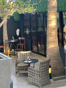 a patio with tables and chairs and a tree at THE PALMS Luxury Boutique Hotel in Dakar