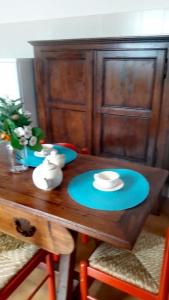 drewniany stół z niebieskimi płytami i kapeluszem w obiekcie Casa La Rondine. Un panorama sospeso sulla natura w mieście Carro