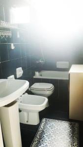 bagno con servizi igienici bianchi e lavandino di Casa La Rondine. Un panorama sospeso sulla natura a Carro