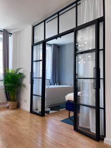 a sliding glass door in a room with a tub at Holiday Apartment Old Town Gdansk with a Jacuzzi in Gdańsk