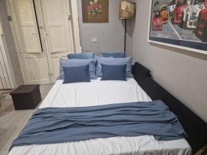 a bed with blue pillows in a bedroom at Casa Rita-Superior Room in Giarre