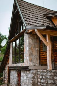 eine Blockhütte mit Fenstern und einem Dach in der Unterkunft Planinska Koliba ABA-TARA in Bajina Bašta