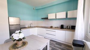 una cocina con armarios blancos y una mesa con flores. en Appartement confortable - Gare, en Épinal 7 fotos más