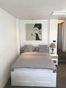 1 dormitorio con 1 cama en una habitación blanca en Modern Studio Apartment with harbour views, en Penzance