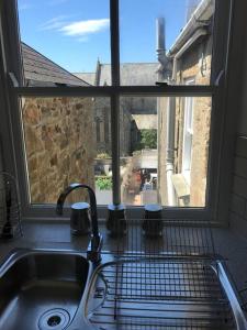 fregadero de cocina con vistas a una ventana en Modern Studio Apartment with harbour views, en Penzance