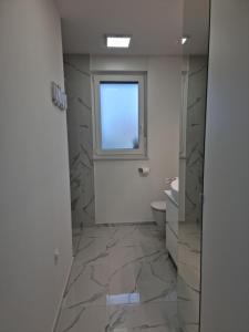 a bathroom with a window and a sink and a toilet at Luxury Apartment Umag in Umag