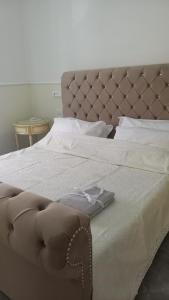 a large bed with a brown tufted headboard at PALAZZO NOVECENTO Rooms in Lecco