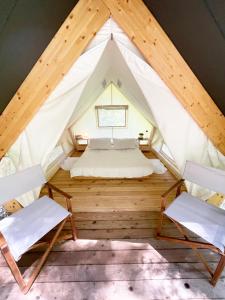Oplotnica的住宿－Glamping Tent Water Village Rogla，帐篷内的房间,配有一张床和两把椅子