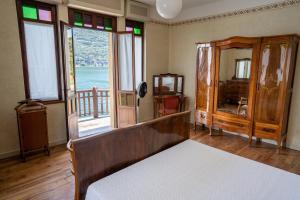 1 dormitorio con cama y ventana grande en Villa Cecilia - pieds dans l'eau, en Sulzano