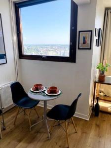 a table and chairs in a room with a window at Le Cassiopée - Vue incroyable surplombant Rennes in Rennes