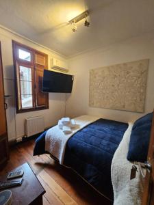 1 dormitorio con 1 cama grande con manta azul en Maktub Montt - Hostal Boutique en Santiago