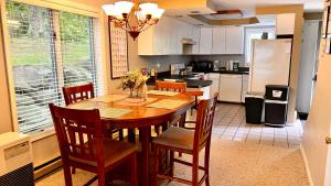 a kitchen with a wooden table with chairs and a refrigerator at Waking up in the Nature in Campton