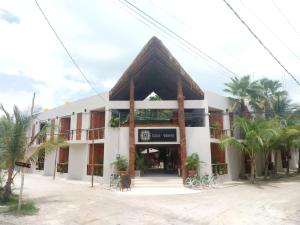 un edificio con una señal delante de él en Hotel Casa del Viento en Holbox Island