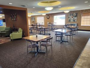 un restaurante con mesas y sillas en una habitación en Highland Suites Extended Stay, en Minot