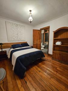 1 dormitorio con 1 cama grande y suelo de madera en Maktub Montt - Hostal Boutique en Santiago