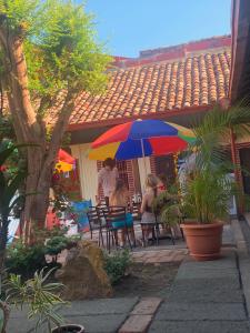 a group of people sitting at a table under an umbrella at Hostal Don Gato in Granada