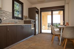 a kitchen with wooden cabinets and a table with chairs at Villa Panoramica in Pylíon